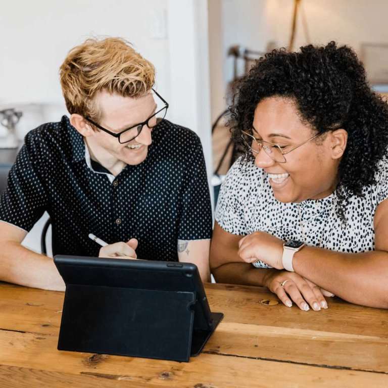 man and woman looking at ipad