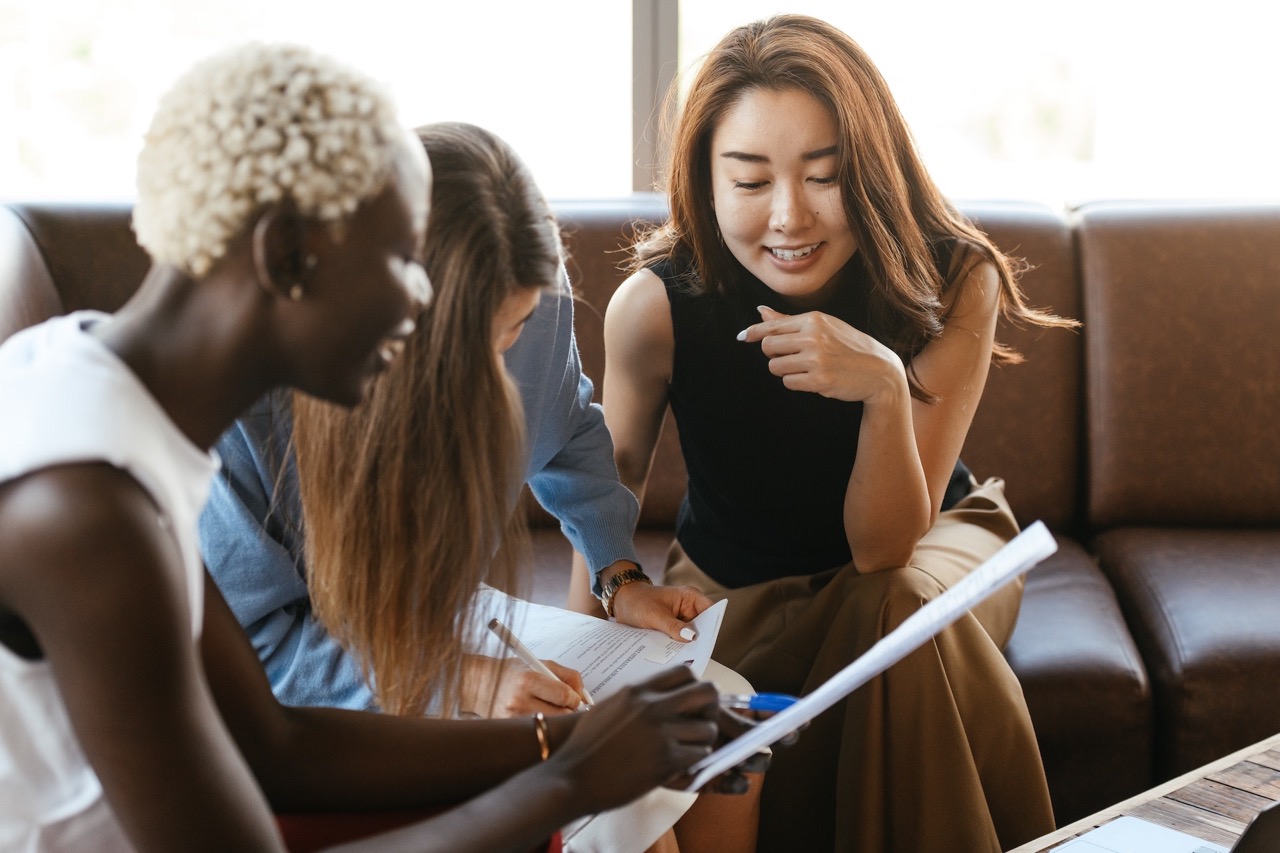 group of female coworkers sitting together working on a project